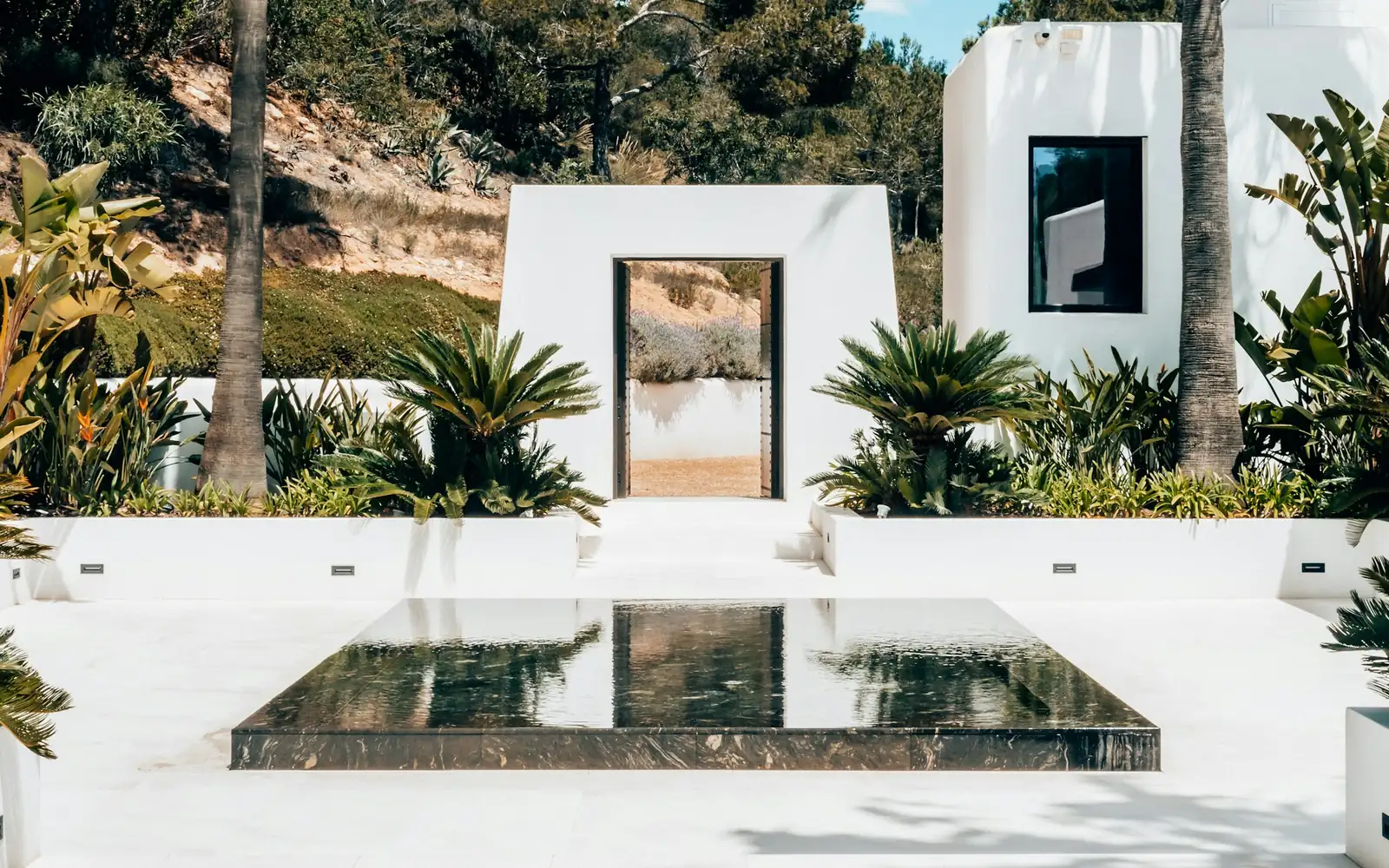 A white villa with a reflecting pool