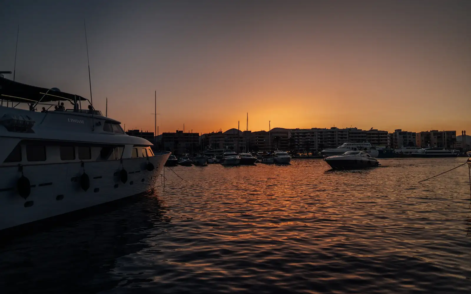 A superyacht in a harbour at sunset