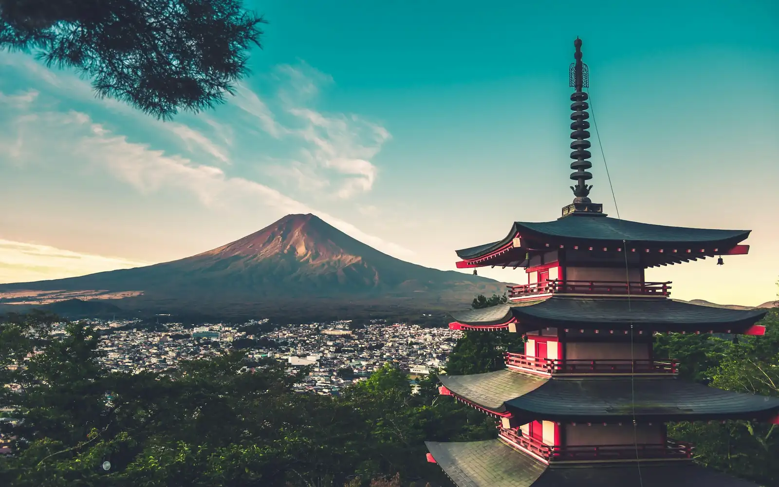 A pagoda below Mount Fuji at sunset