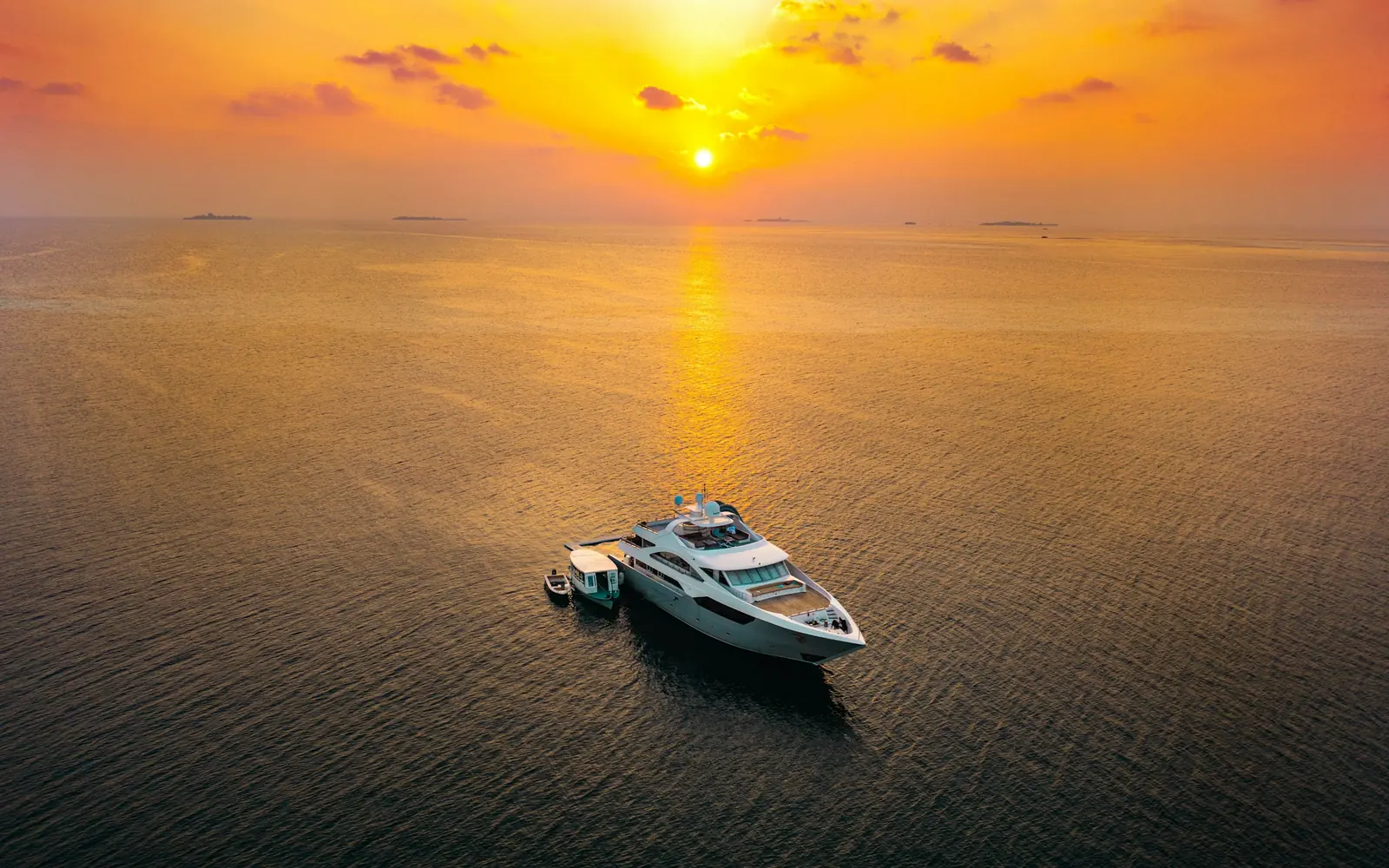 A yacht alone on a golden sea at sunrise
