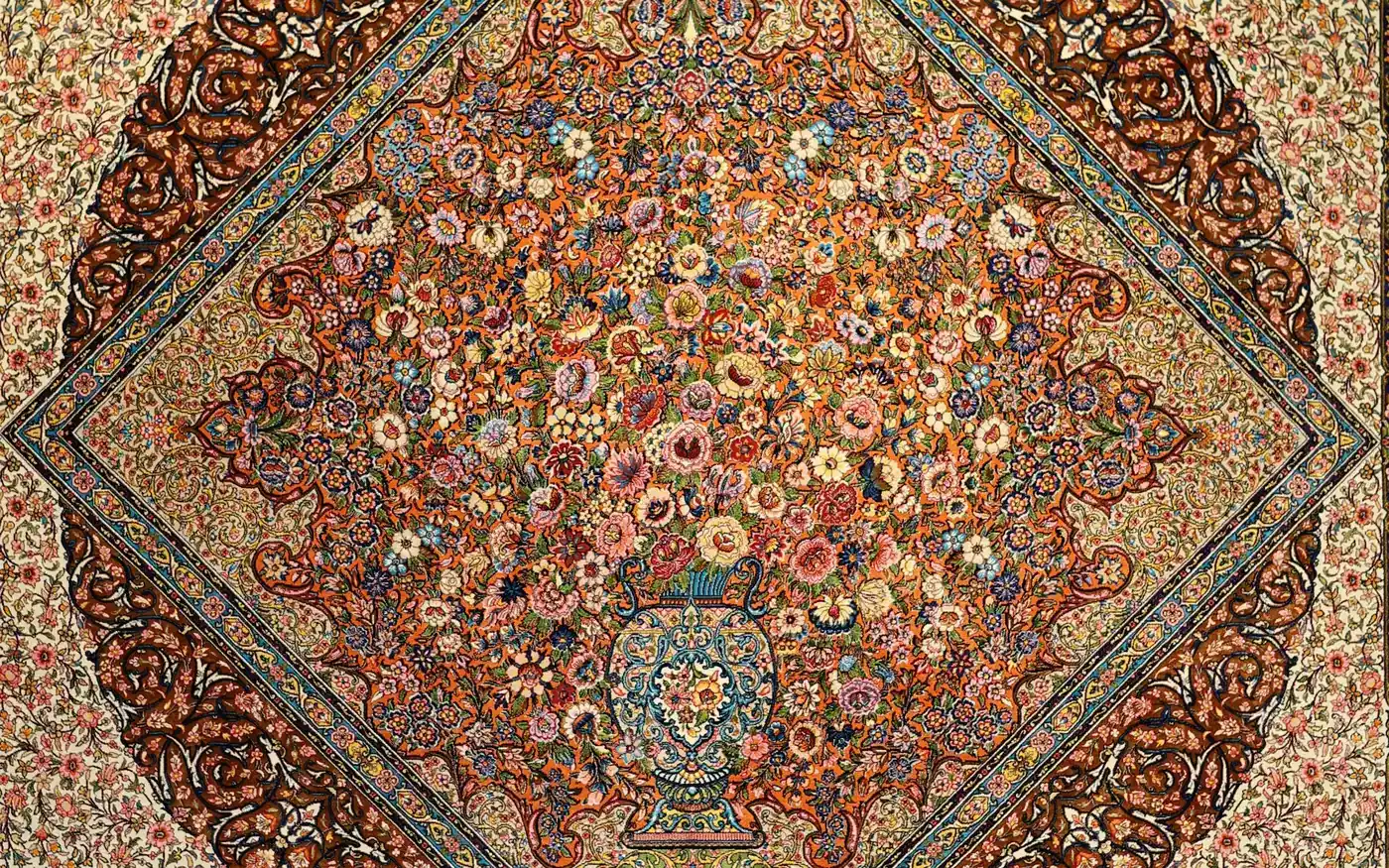 A silk carpet with a medallion of flowers rising from a vase