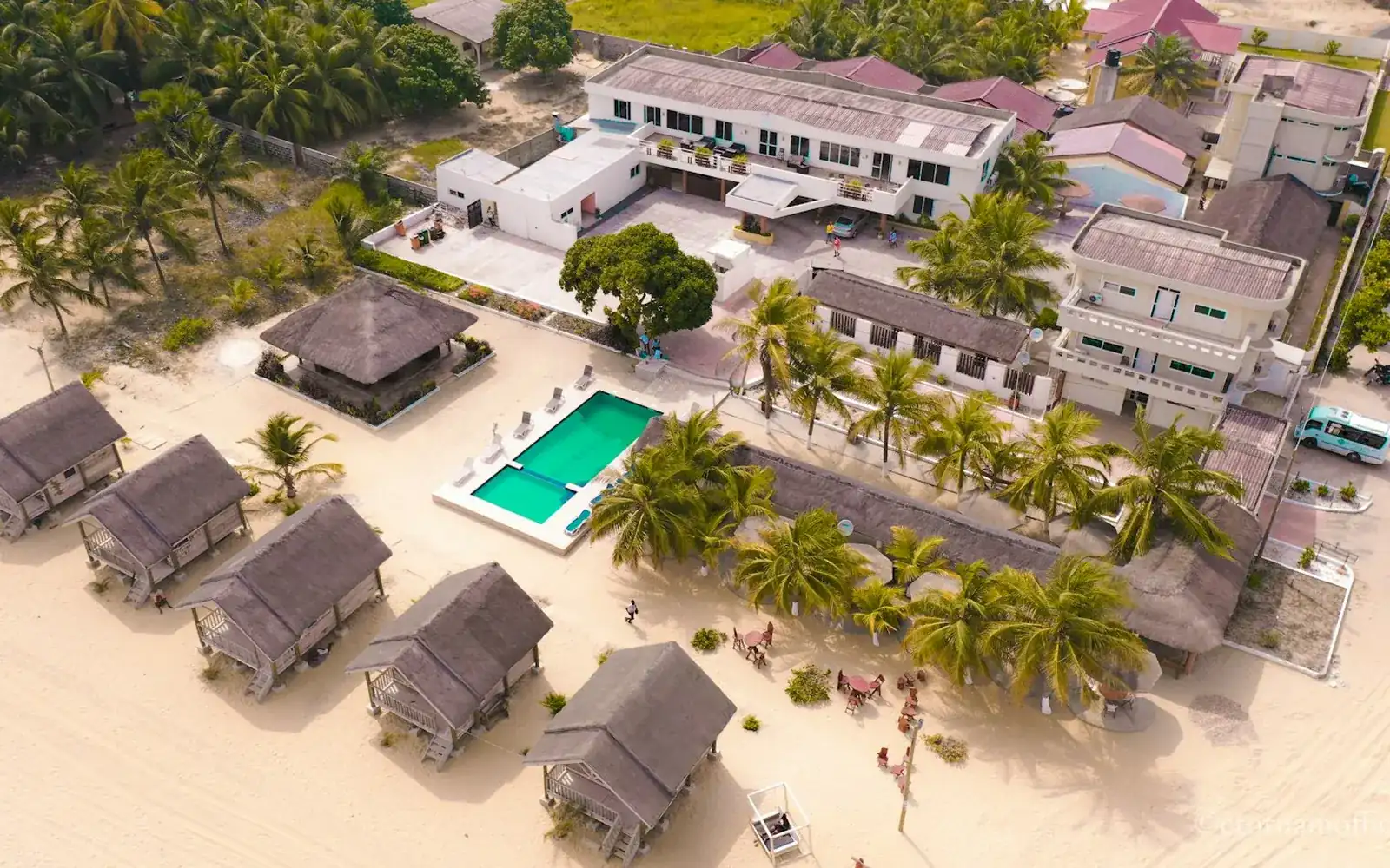 Beach villas beside a golden shore, seen from above